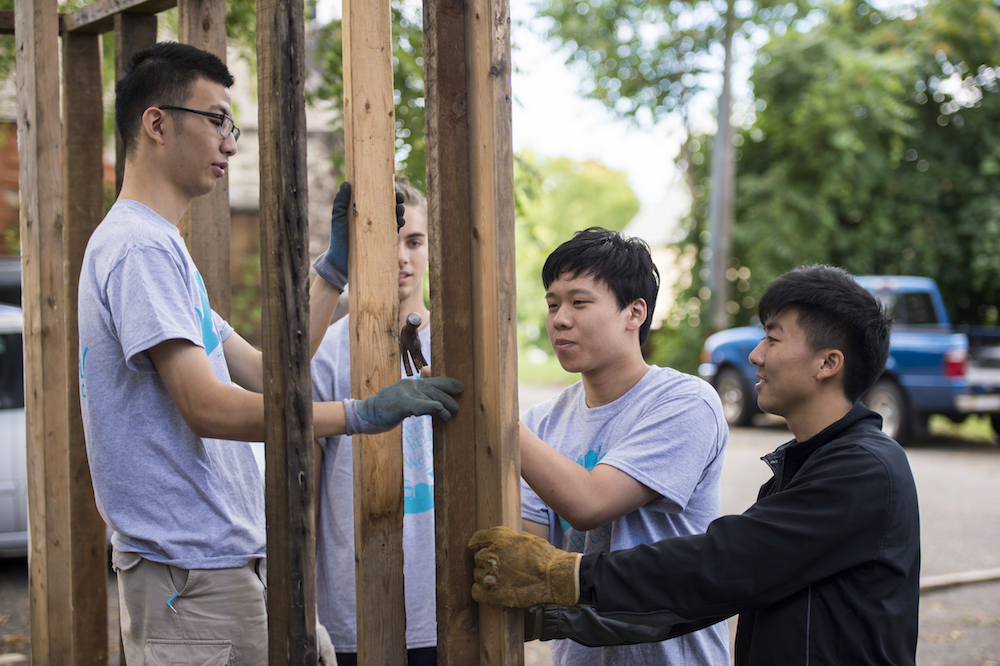 l-r: University of Rochester freshmen Tian Lan of Shanghai, China, Galen Everett of Fairport, NY, Xuefan Hu of Shanghai, China, and Mackenzie Lee of Boise, ID build a chicken coop at the Gandhi House in Rochester during Wilson Day activities August 27, 2015.  // photo by J. Adam Fenster / University of Rochester
